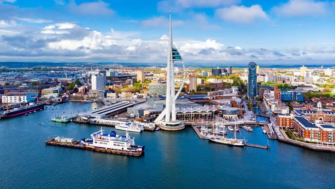 Luftsicht auf den seegelförmigen Spinnaker Tower in Portsmouth. Der markante Turm erhebt sich über die Stadt und bietet einen atemberaubenden Blick auf den Hafen und die umliegende Küstenlandschaft. 