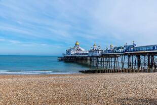 Ein Steg in Eastbourne, East Sussex, England. Der hölzerne Steg ragt ins ruhige Meer hinaus.