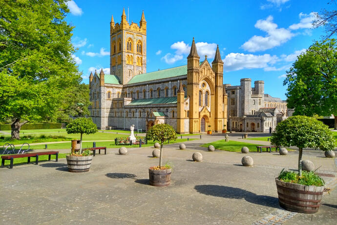 Die Buckfast Abbey in Devon im Hintergrund, umgeben von einem idyllischen Garten.