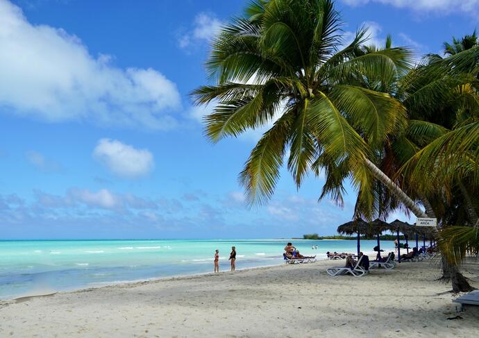 Tropischer Strand von Cayo Coco, Kuba, mit schneeweißem Sand, türkisfarbenem Wasser und malerischen Palmen, die für karibisches Flair sorgen.