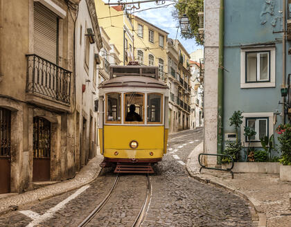 Gelbe Lissabonner Straßenbahn in enger Gasse