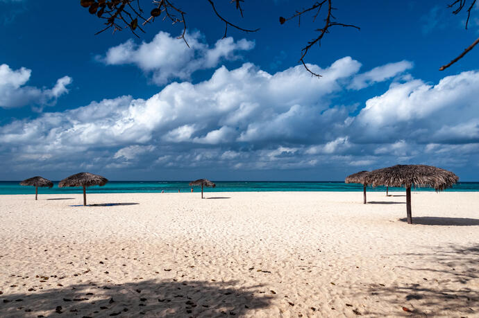 Blick auf den weißen Sandstrand am Club Amigo in Guardalavaca, Kuba, mit goldenem Sand und tropischer Kulisse.