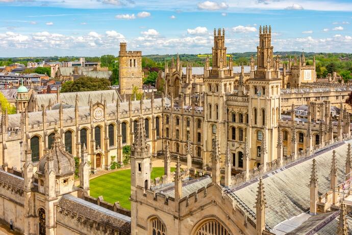 Luftaufnahme von Oxford mit Blick auf das All Souls College. Die beeindruckende Architektur des Colleges mit seinen markanten Türmen und symmetrischen Innenhöfen steht im Zentrum der historischen Stadtlandschaft.